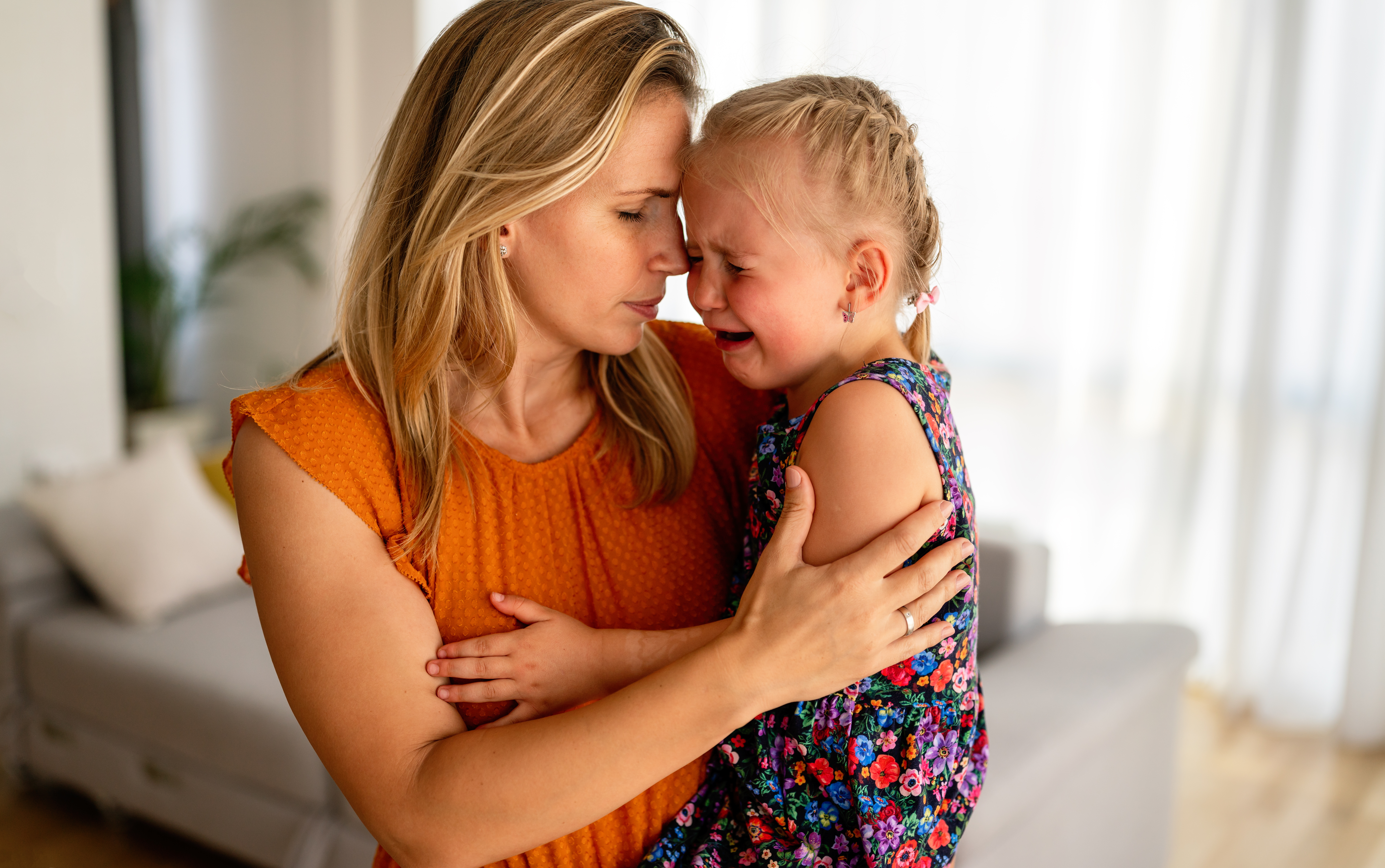Mother comforting her crying little girl. Parenthood, family support concept